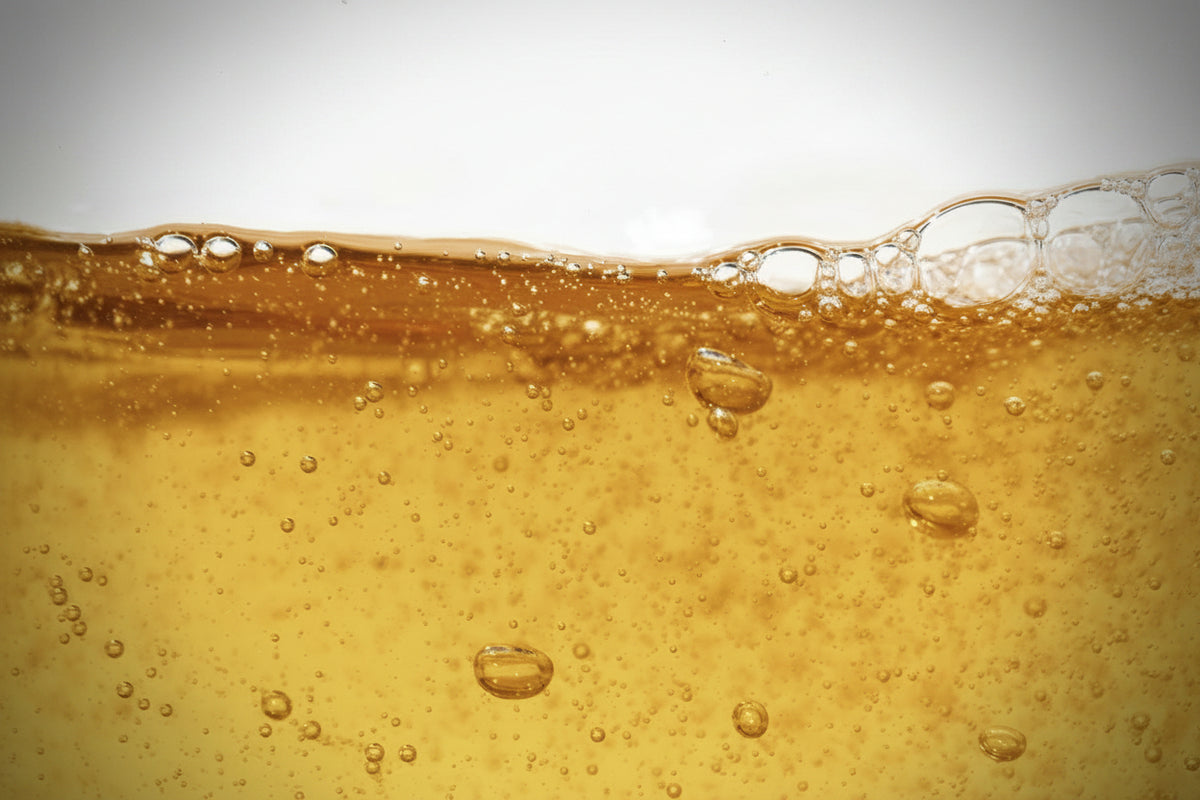 Macro photograph of fermented natural fruit acids against a white background.