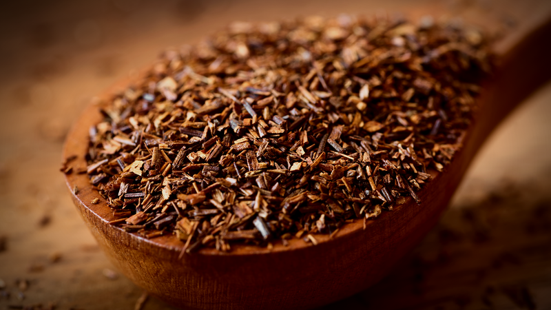 Finely cut rooibos leaves in a wooden spoon, Aspalathus linearis.